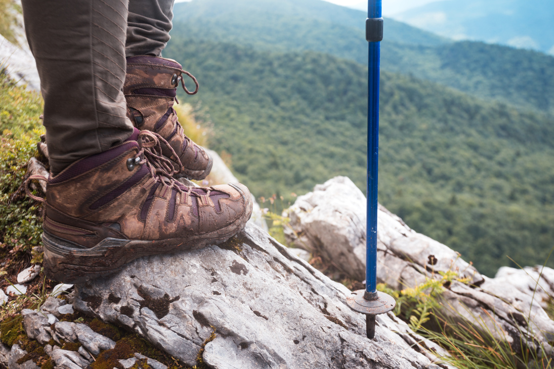 Person Wearing Hiking Boots and Holding Trekking Pole